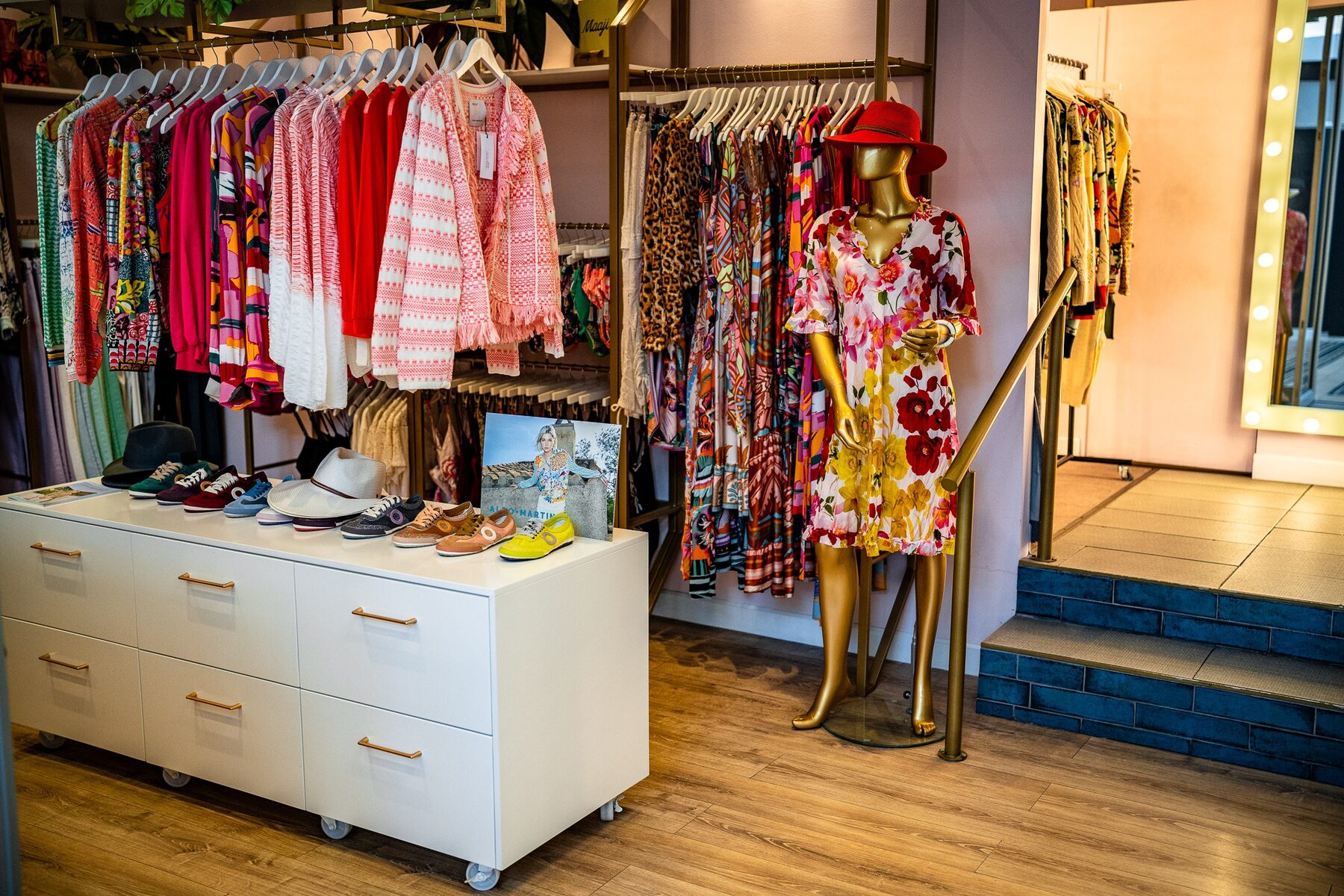 A gold female mannequin presenting a floral collection in a Colour Box store