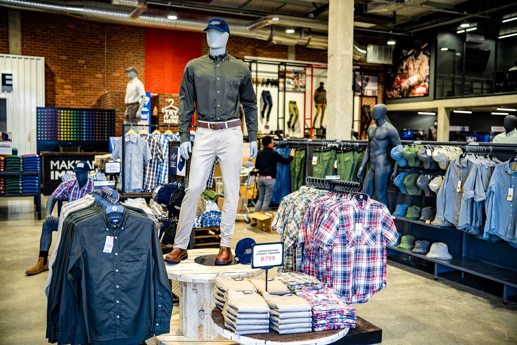A group of male mannequins arranged through a workwear store